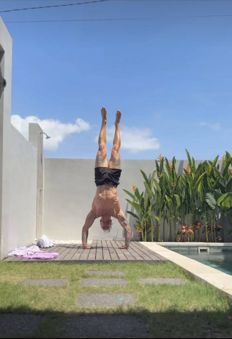 Gints Valdmanis balancing in a handstand beside a pool in Bali